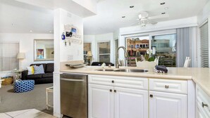 A modern kitchen with white cabinets, a stainless steel dishwasher, and a double sink. - 5N-31 Beach View, BBQ & Jacuzzi! (Oceanside)