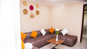 A modern living room with a sectional sofa, a wooden coffee table, and decorative wall hangings.