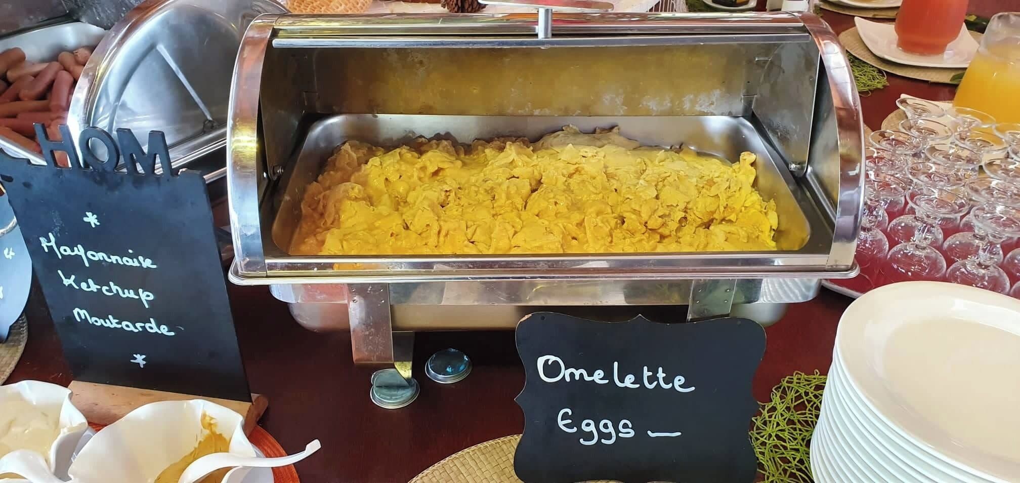 A buffet with a sign indicating 'Mayonnaise, Ketchup, Mustard' and another sign for 'Omelette, Eggs'.