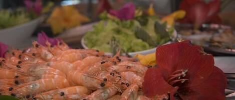 A seafood platter with shrimp and a red flower.