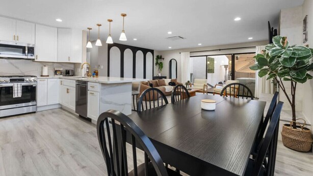A modern kitchen with white cabinets, a central island, and pendant lighting. - Wellness Bnb - Your San Diego Retreat! (San Diego)
