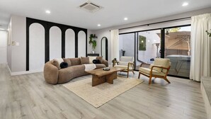 A modern living room with a sectional sofa, a wooden coffee table, and a chair. - Wellness Bnb - Your San Diego Retreat! (San Diego)