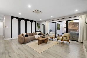 Ein modernes Wohnzimmer mit einem Ecksofa, einem Holztisch und einem Sessel.