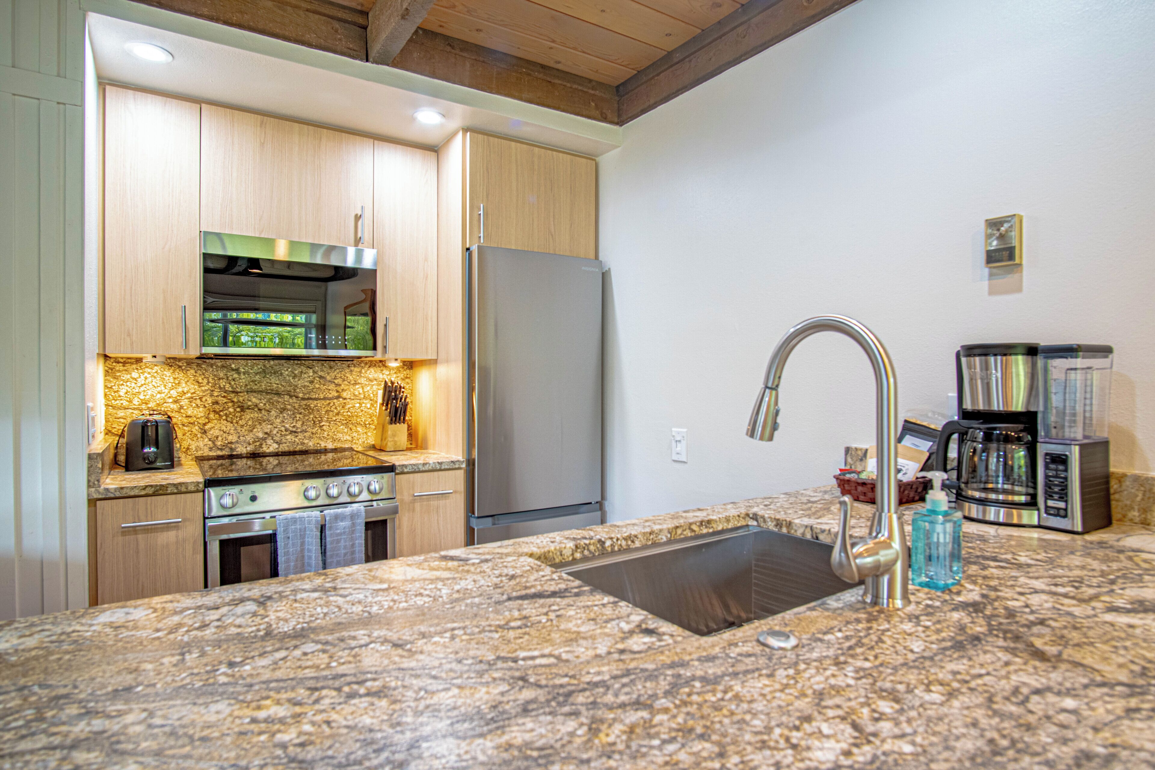 A kitchen with granite countertops, stainless steel appliances, and wooden cabinets.