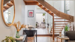 Un interior moderno con una escalera de madera, un comedor y una sala de estar.