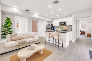 A modern apartment with a living room, kitchen, and dining area.