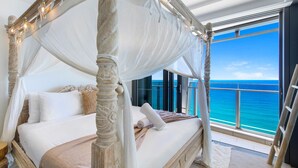 A four-poster bed with a canopy, a view of the ocean, and a balcony with a railing. - Infinity Oceanview 2 Bedroom Suite - The Langham (Surfers Paradise)