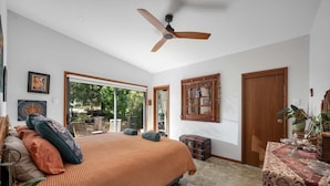 A bedroom with a bed, a ceiling fan, a sliding glass door to a balcony, and a wooden door. - Hyams Reach Retreat - Jervis Bay stay, pets welcome (Shoalhaven City Council)