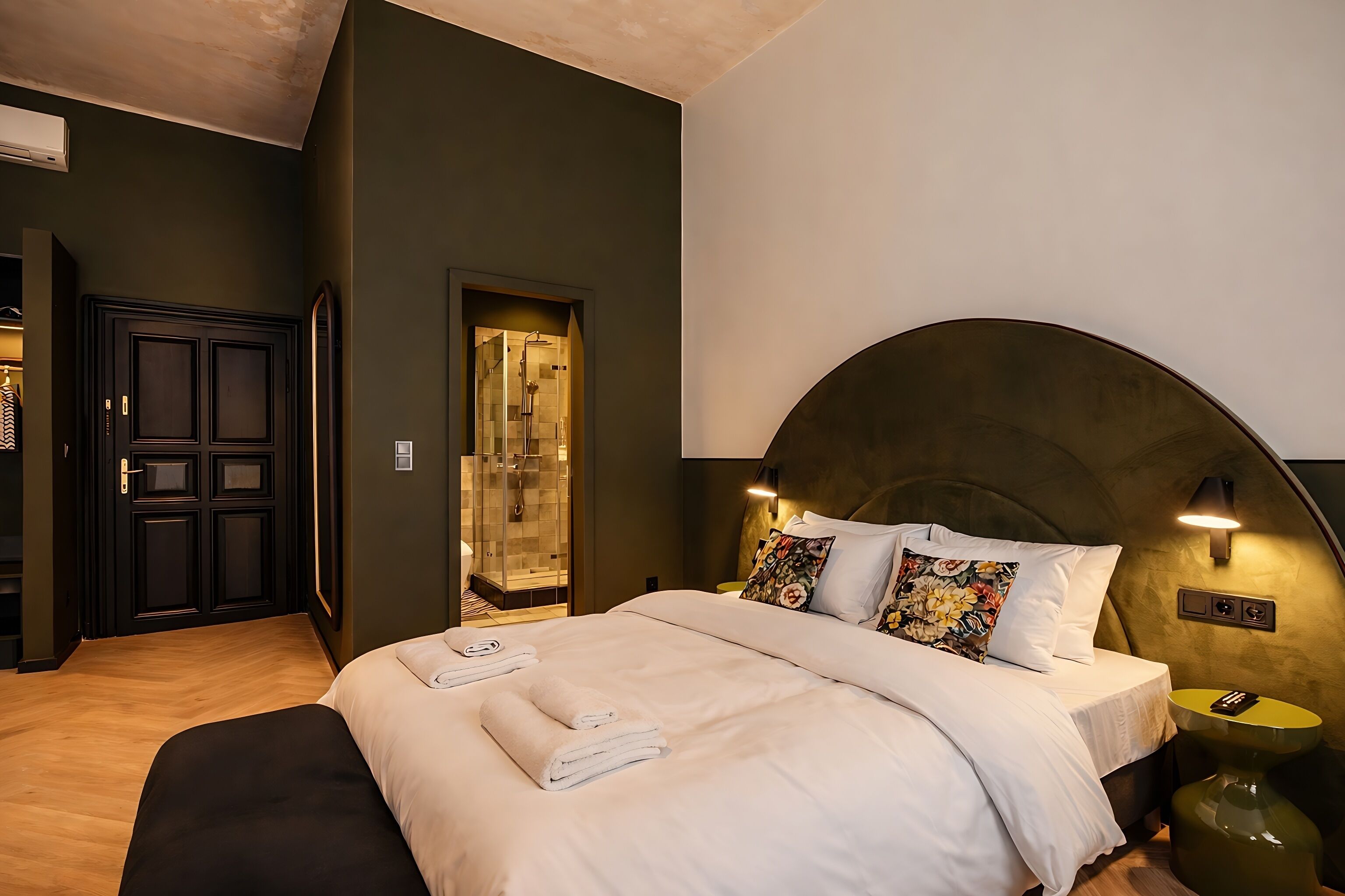 Een moderne hotelkamer met een groot bed, een inloopkast en een douche.