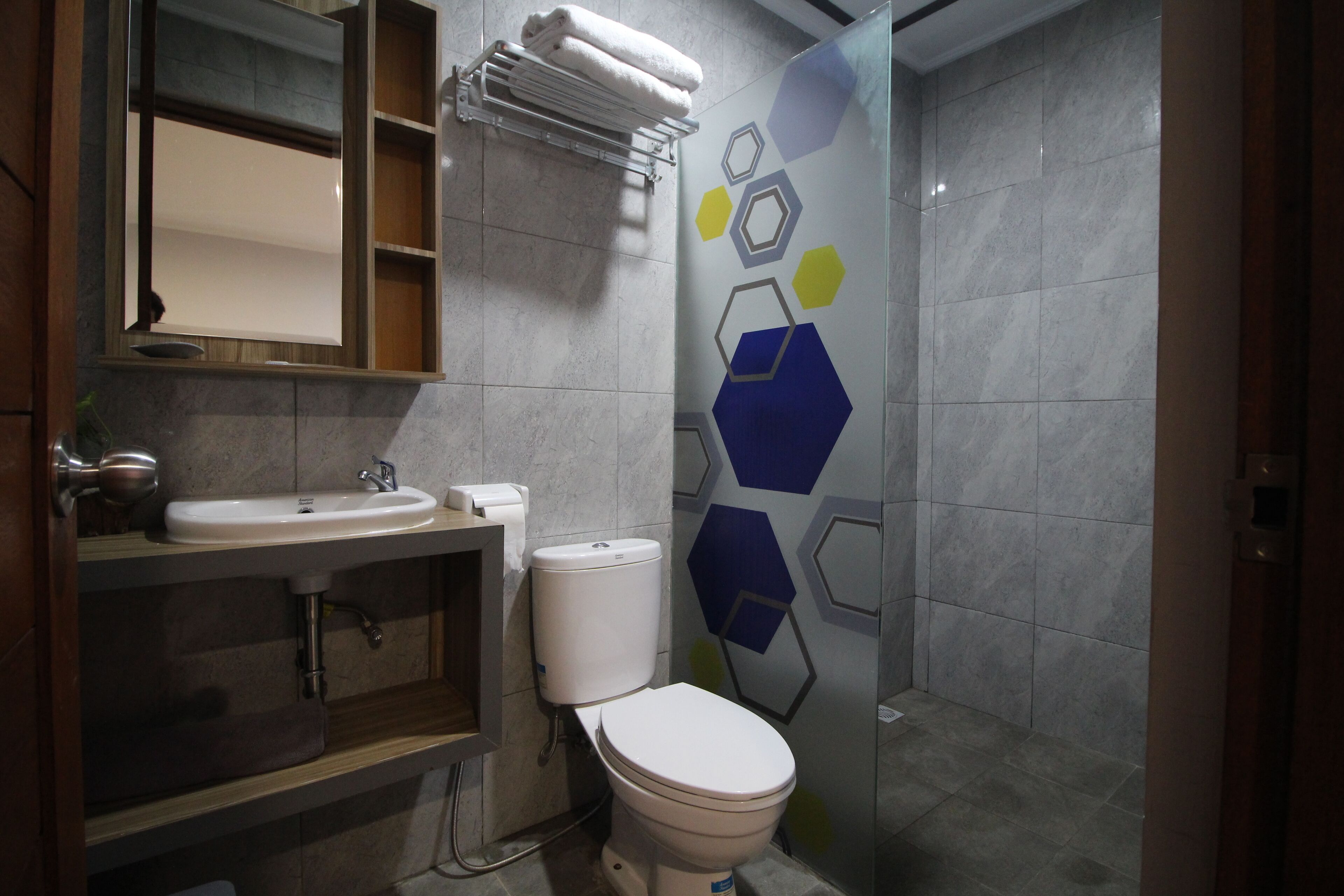 Een badkamer met een wastafel, toilet en spiegel.