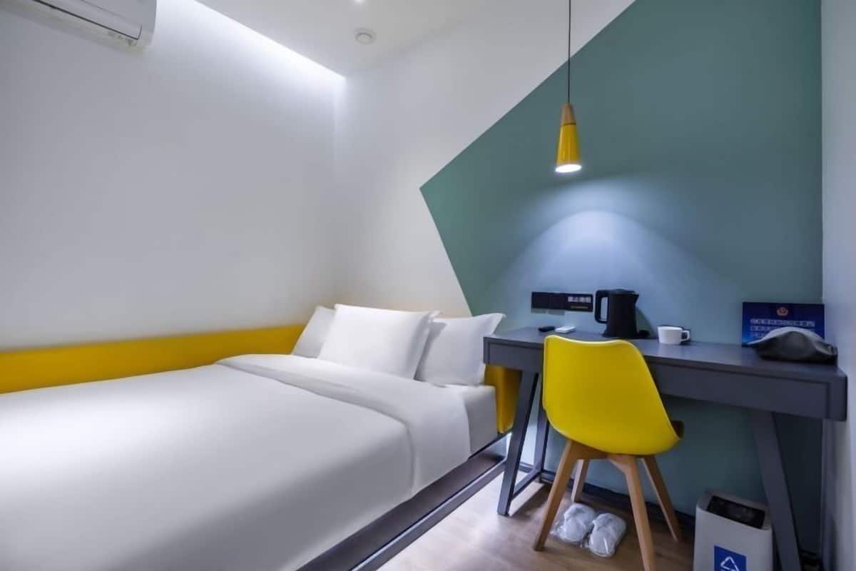Une chambre d’hôtel équipée d’un lit, d’un bureau, d’une chaise et d’une machine à café.