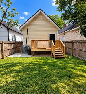 A wooden deck with a bench and stairs leading to a house with a gabled roof. - Cozy 2BR Downtown Retreat Just 5 Min to UF Health (Jacksonville)