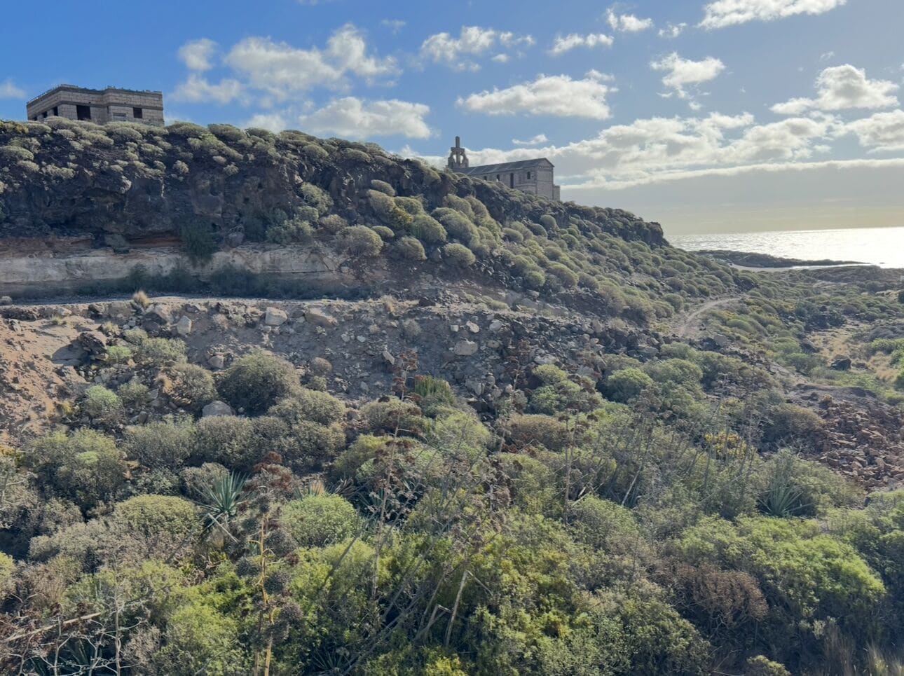 A coastal landscape with rocky terrain and sparse vegetation.