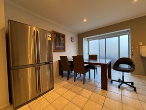 A kitchen with a stainless steel refrigerator, a dining table with chairs, and a large window. - Luxury Townhouse at Box Hill Centre ( accommodate 6 persons) (Box Hill)