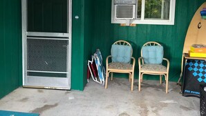 A room with a green wall, two chairs, a window, and a surfboard. - Cozy studio in peaceful Kailua-Kona with refreshing AC (Kailua-Kona)