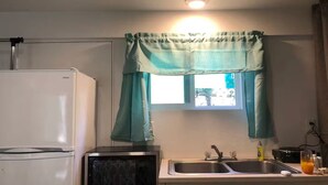 A compact kitchen with a white refrigerator, a microwave, and a sink. - Cozy studio in peaceful Kailua-Kona with refreshing AC (Kailua-Kona)