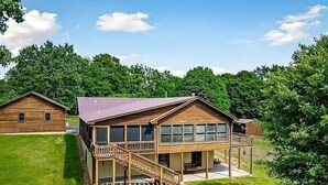 A two-story wooden house with a balcony and a covered porch.