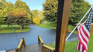 A wooden deck leading to a road with an American flag.