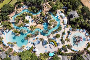Vista aérea de un resort con varias piscinas, zonas de descanso y palmeras.