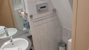 A bathroom with a sink, mirror, toilet, and a towel rack. - This one bedroom is located in a beautiful Historic Villa in Landstuhl, Germany (Landstuhl)