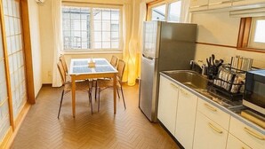 A kitchen with a dining table, chairs, a refrigerator, and a sink. - Lake View Entire House｜Relaxing Private Stay in Nature (Minamikomatsu, Otsu City)