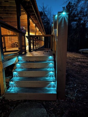 A wooden staircase with illuminated steps leading to a porch. - Serene 3-bedroom cabin in charming Eclectic 10 mins to monster mountain,
(Eclectic)