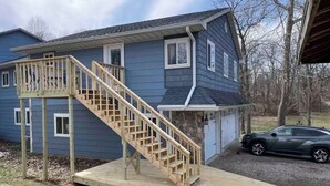 A two-story house with a wooden staircase leading to a deck. - 8 miles From IU Campus: Country & Quiet  2-BR apt  in charming Ellettsville (Ellettsville)