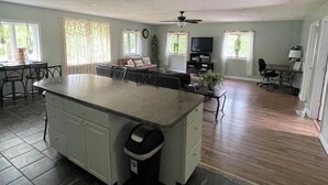 A spacious kitchen with a large island, dark tiled flooring, and a ceiling fan. - 8 miles From IU Campus: Country & Quiet  2-BR apt  in charming Ellettsville (Ellettsville)