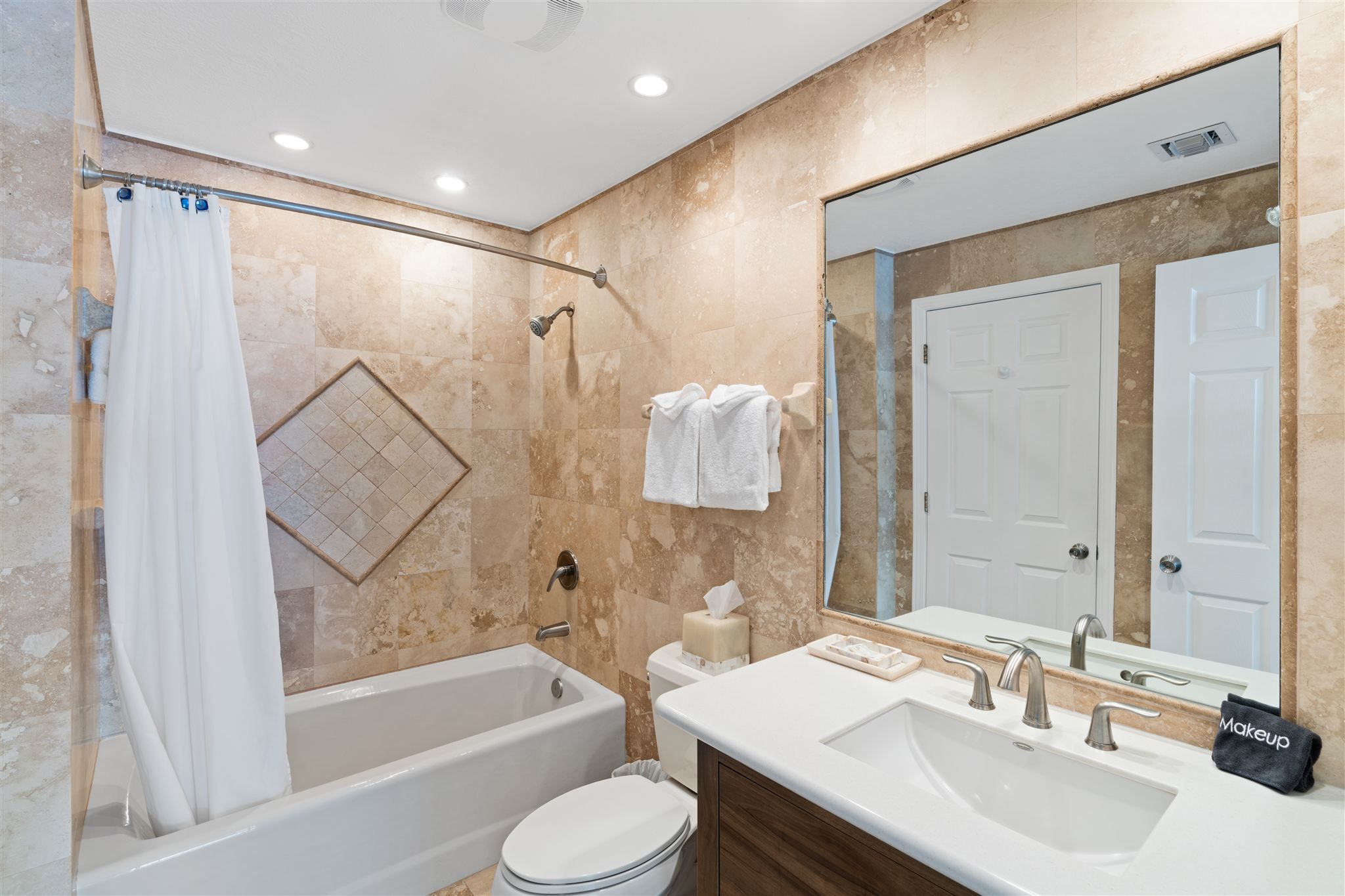 Une salle de bain avec une baignoire, des toilettes, un lavabo et un miroir.