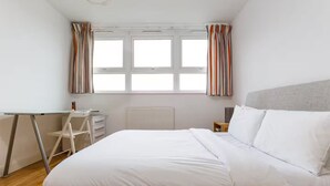 A bedroom with a bed, a desk, and a chair. - Bright & Spacious 2 Bed Islington Flat | Fast Wi-Fi (London)