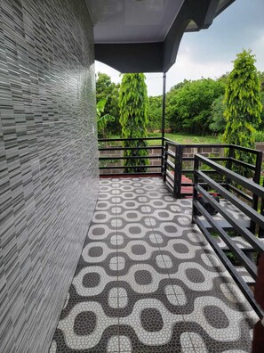 A covered balcony with a patterned floor, a metal railing, and a view of greenery. - 2-bedroom house with - Spectacular Lakefront -AC in charming Granada (Granada)