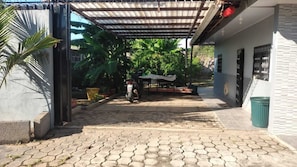 A paved courtyard with a covered seating area, a scooter, and a trash bin. - 2-bedroom house with - Spectacular Lakefront -AC in charming Granada (Granada)