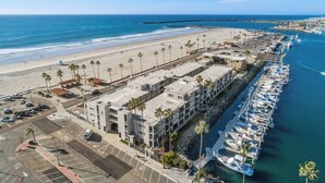 Un hôtel situé sur la côte, avec vue sur la plage, un parking et un port de plaisance.