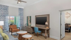 A modern living room with a flat-screen TV, a desk, and a sofa. - Harborside at Atlantis – Premium 2-Bedroom Villa with Full Resort Access (N.P)