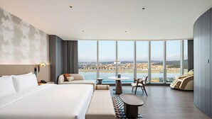 A hotel room with a large bed, a seating area with a view, and a dining table. - Oryard Hotel Changsha Juzhou (Changsha)