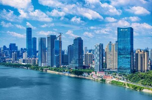 Un horizonte urbano con rascacielos modernos, un río y cielo despejado.