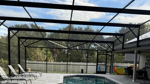 Ein überdachter Pool mit Liegestühlen und einer Sonnenterrasse.