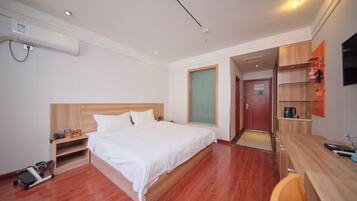 Una habitación de hotel con cama, escritorio, silla y televisor.