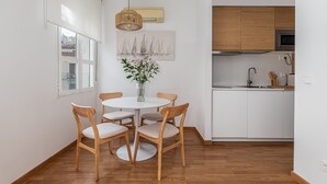 Eine moderne Küche mit weißen Schränken, einer eingebauten Mikrowelle und einer Spüle aus Edelstahl.