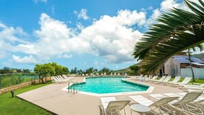 Una piscina con lettini e una palma.
