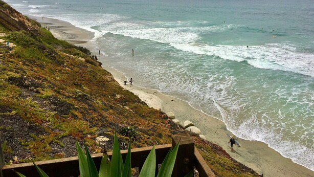 A coastal beach with a sandy shoreline and rocky cliffs. - Cozy 1-bedroom beach bungalow in beautiful Encinitas 1 block from surf with AC (Encinitas)