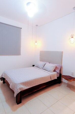 Ein Schlafzimmer mit Bett, Nachttisch und einer Wandleuchte.