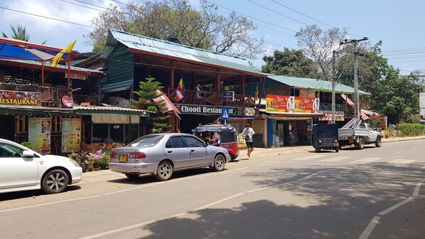 A street with a restaurant named 'Chooti Restaurant' and a sign for 'Sigin Cafe'. - Nilmini Lodge (Sigiriya)