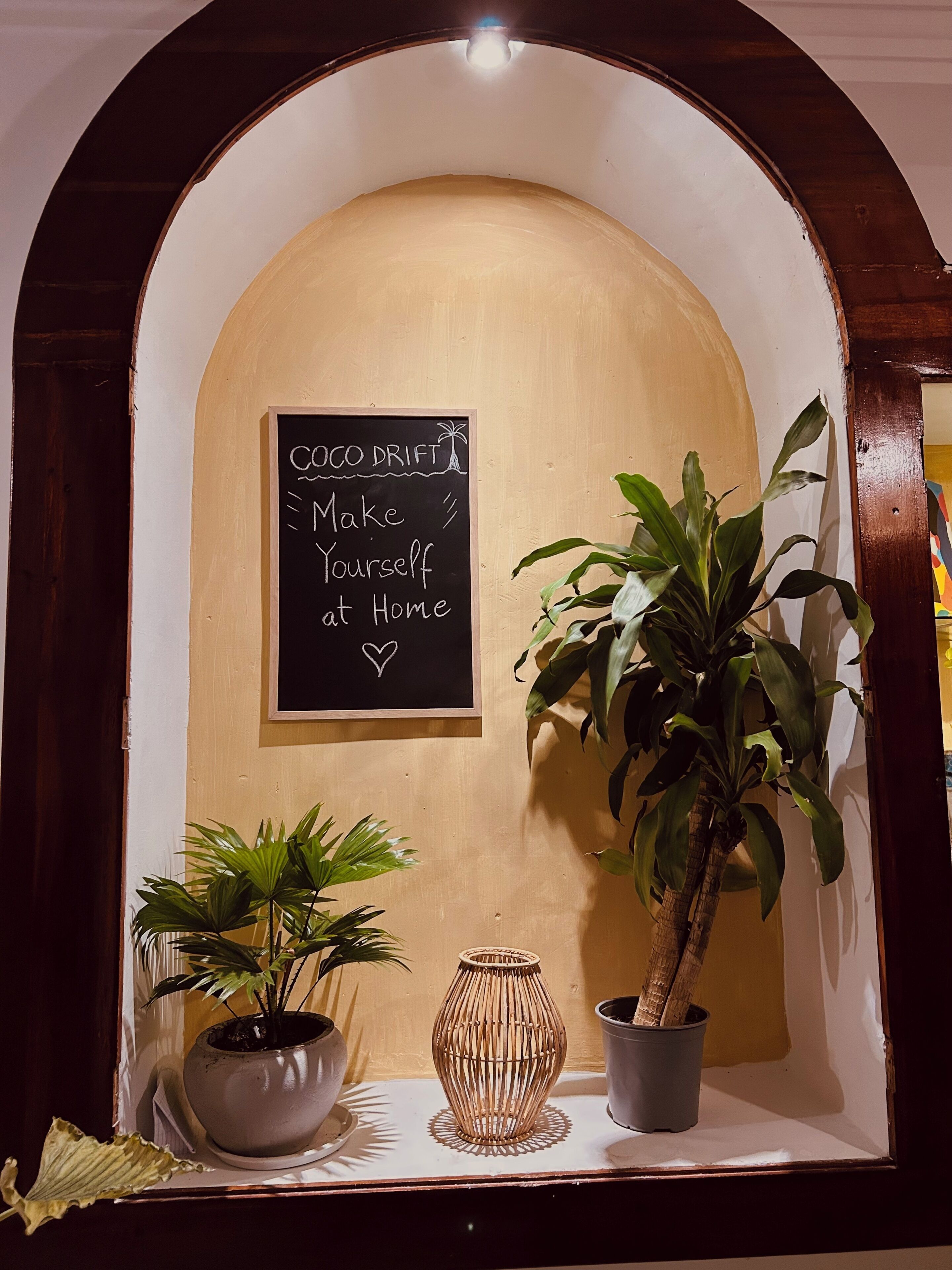 A chalkboard with a menu, a potted plant, and a decorative vase.