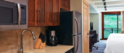 Una cocina moderna con armarios de madera, electrodomésticos de acero inoxidable y una cafetera.