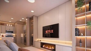 Ein modernes Wohnzimmer mit Kamin, einem flachbildfernseher an der Wand und einem Bücherregal mit Pflanzen.