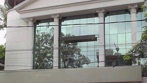 A building with a classical architectural style, featuring a prominent pediment and columns. - Holidayhomecochin  (Kanayannur)