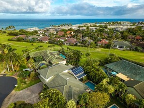 A residential area with houses, a swimming pool, and a view of the ocean.