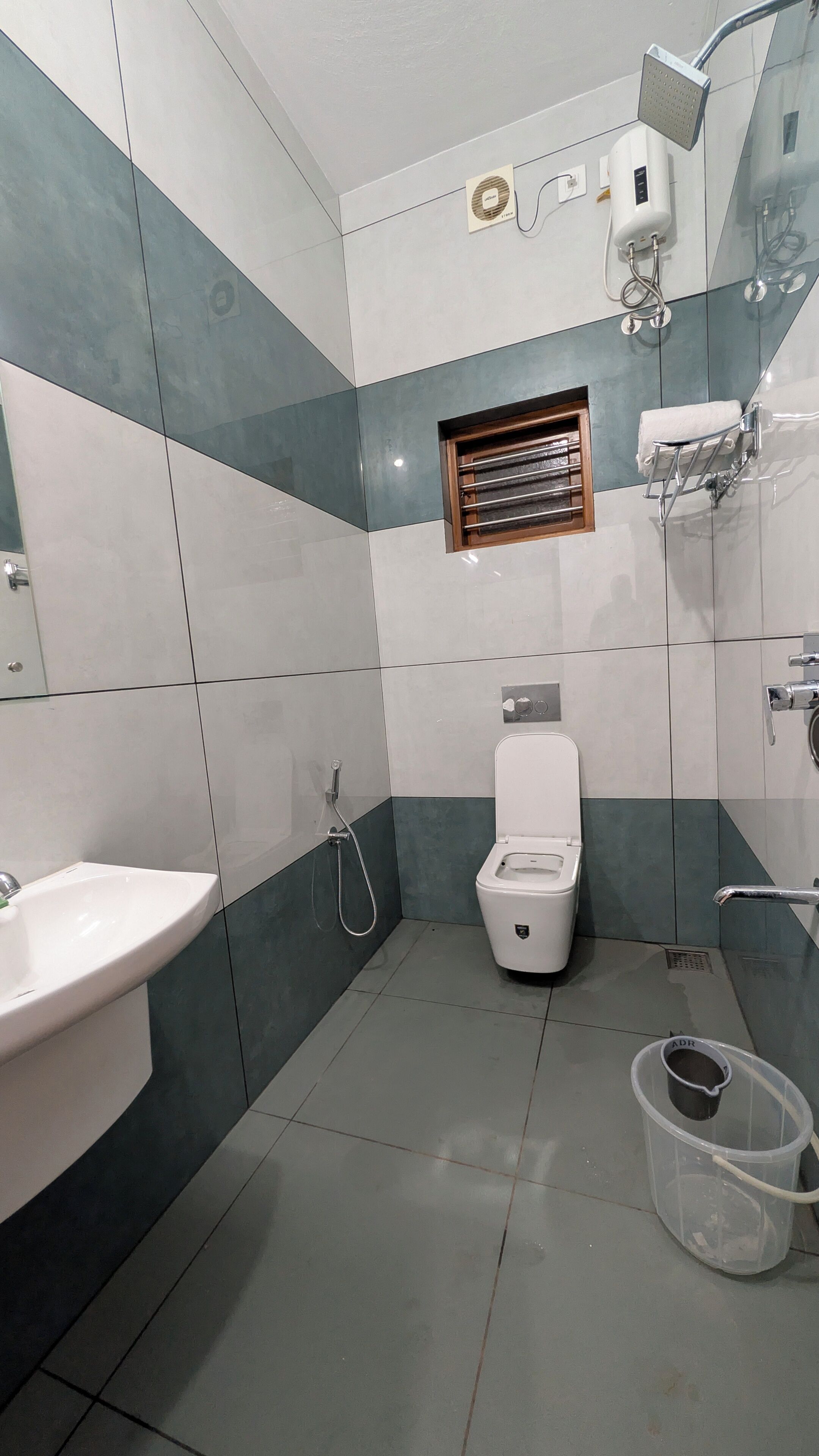 Ein Badezimmer mit Toilette, Waschbecken, Dusche und Fenster.