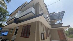 Un immeuble résidentiel à plusieurs étages, doté d’un toit plat, d’un balcon et d’une porte bien visible.